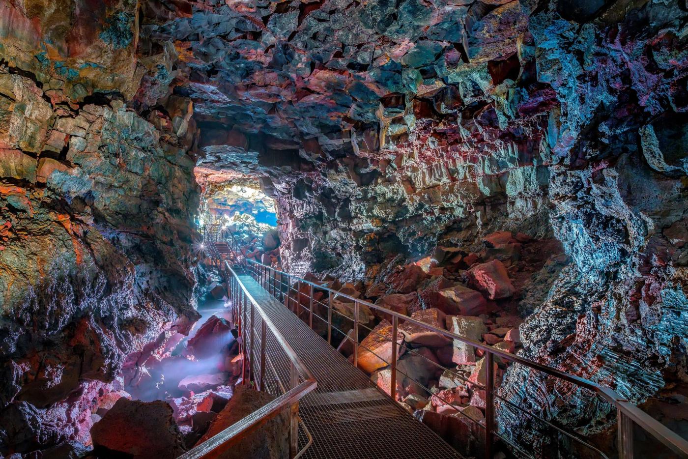 Illuminated walkway inside a volcanic lava tube