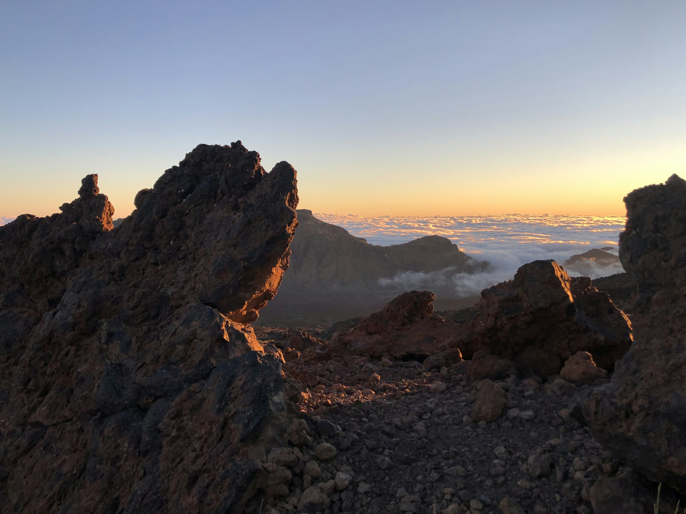Hiker on a volcanic ridge trail in Tenerife with Atlantic Ocean views